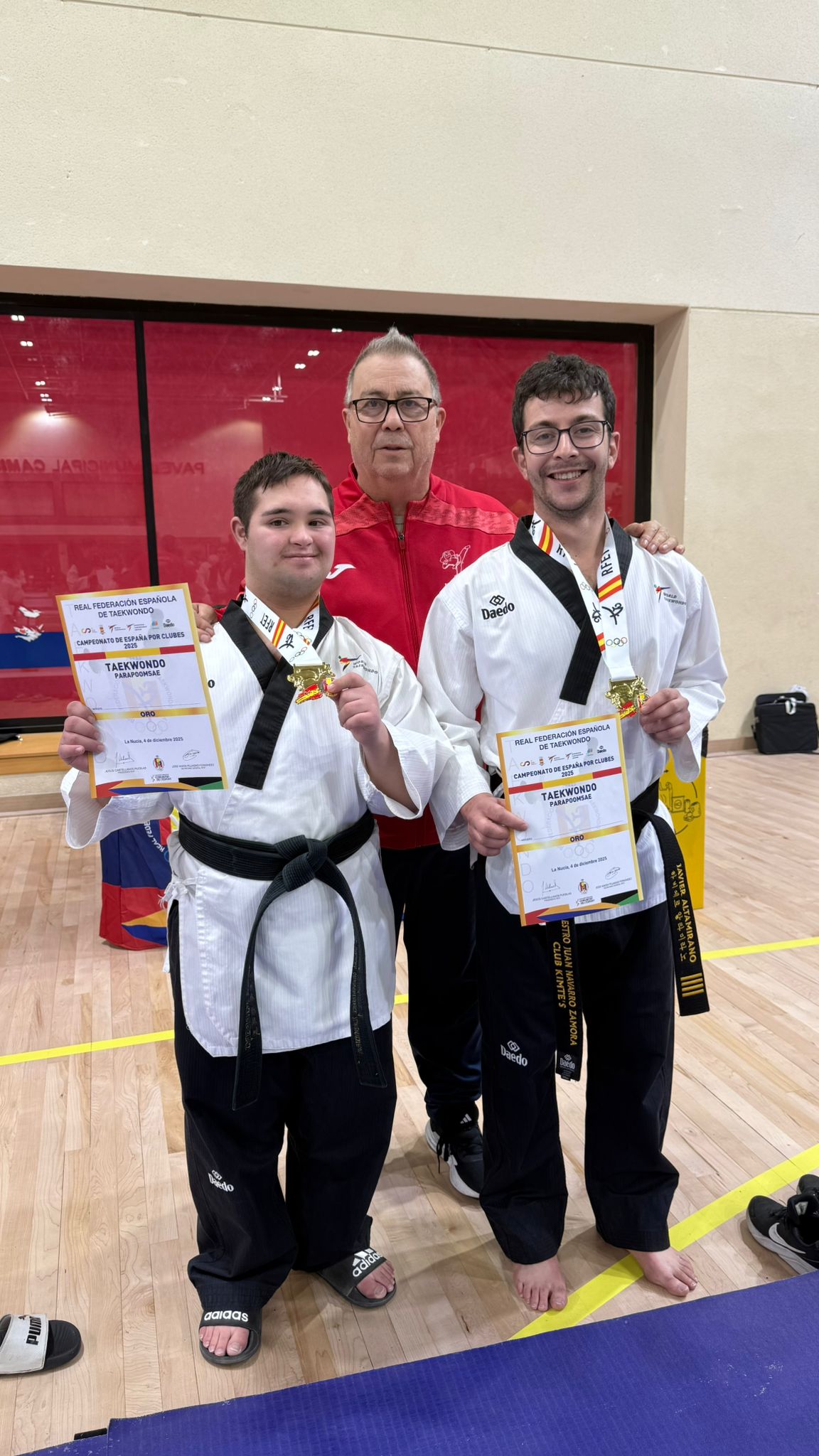 Juan Navarro con dos deportistas de para taekwondo y sus medallas