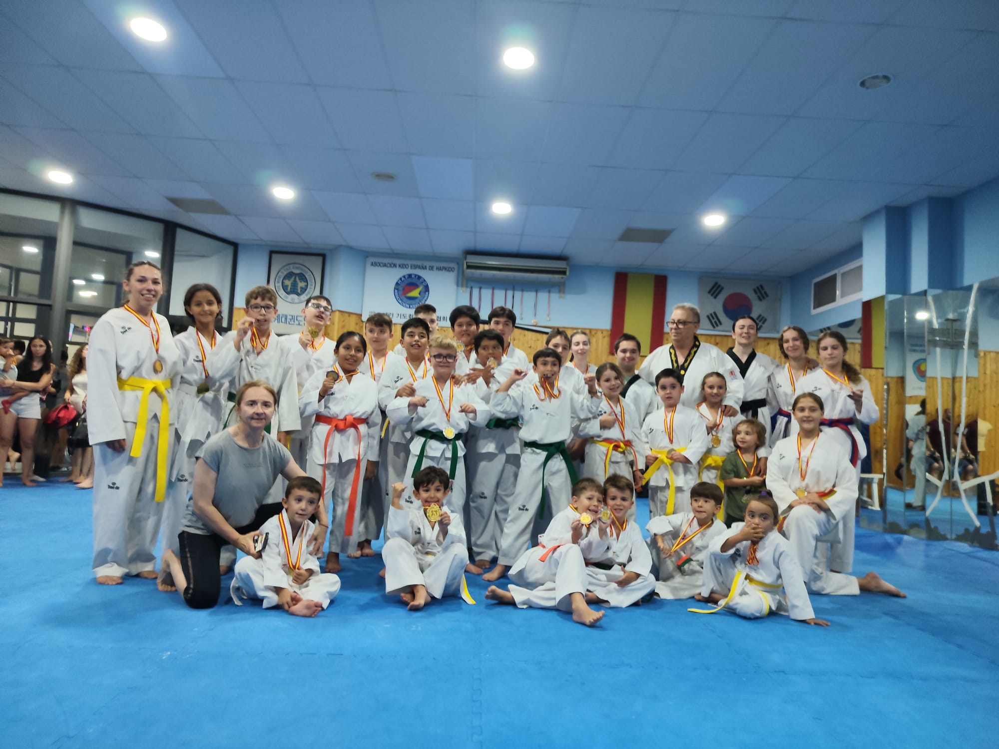 Grupo de alumnos y entrenadores de taekwondo de Kimte’s con medallas